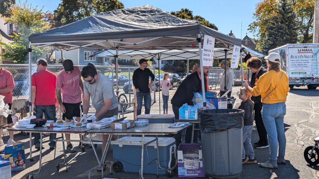 Bratwursts being made and sold under a tent.